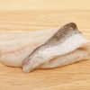 Raw hake fish fillet on a wooden board